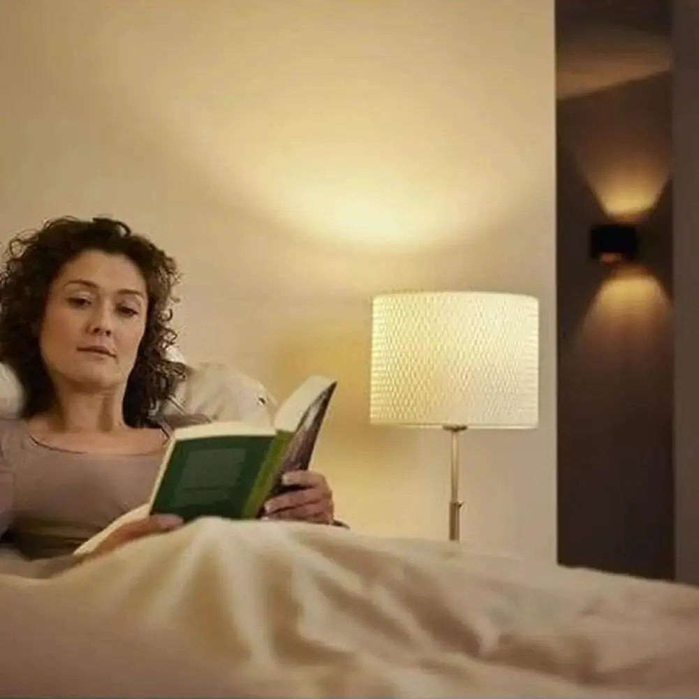 Philips CorePro LEDcapsule G4 2W bulb, warm white (827), bedside lamp scene with a woman reading in bed. UAE