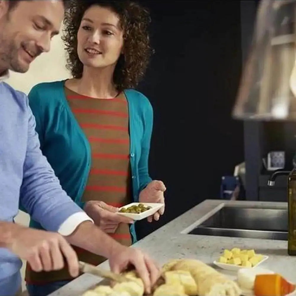 Lifestyle image of a couple in a modern kitchen, preparing bread and cheese on the counter. UAE