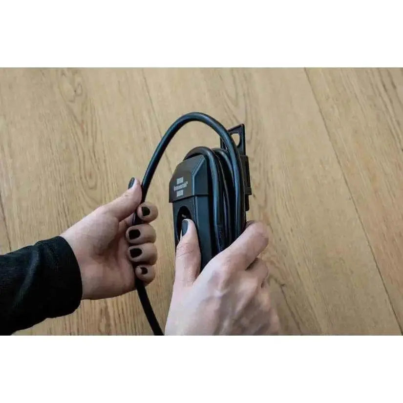 Brennenstuhl Premium-Line Multistandard 5-way extension lead with 5 m cable, black, held by hands on a wooden floor UAE