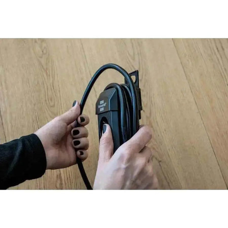 Brennenstuhl Premium-Line Multistandard 5-way extension lead with 5 m cable, black, held by hands on a wooden floor UAE