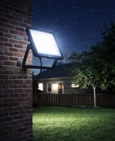Philips SmartBright G5 LED floodlight, 200W, 6500K, 20000lm, wall-mounted on brick, illuminating a nighttime backyard. UAE