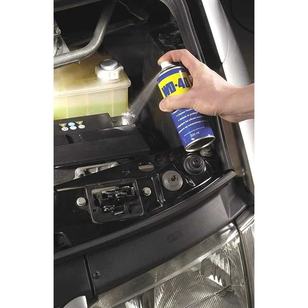 WD-40 Multi-Use Product Original Rust Remover, 330ml, hand spraying near car engine bay. UAE